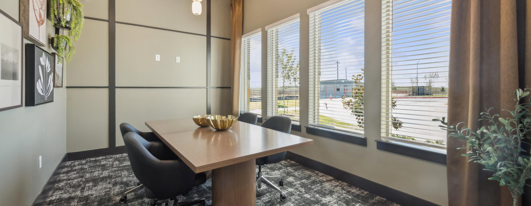 a room with a table and chairs and a large window